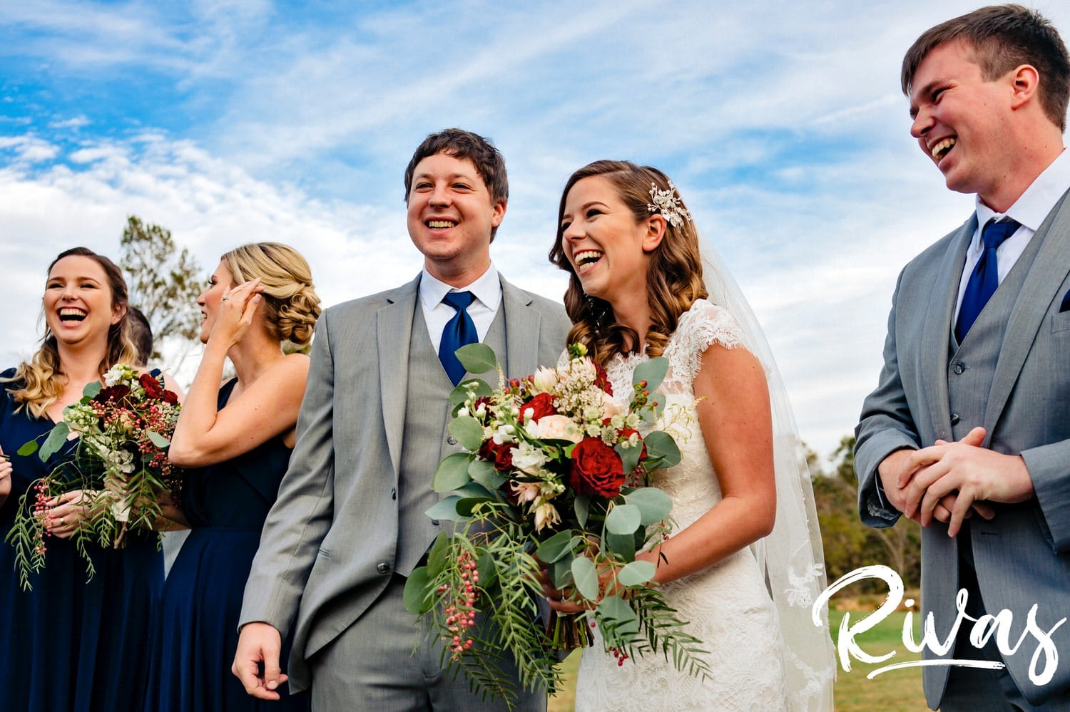 A colorful picture of a bride and groom laughing with their wedding party on the afternoon of their fall wedding day at The Barns at Hamilton Station Vineyard. 