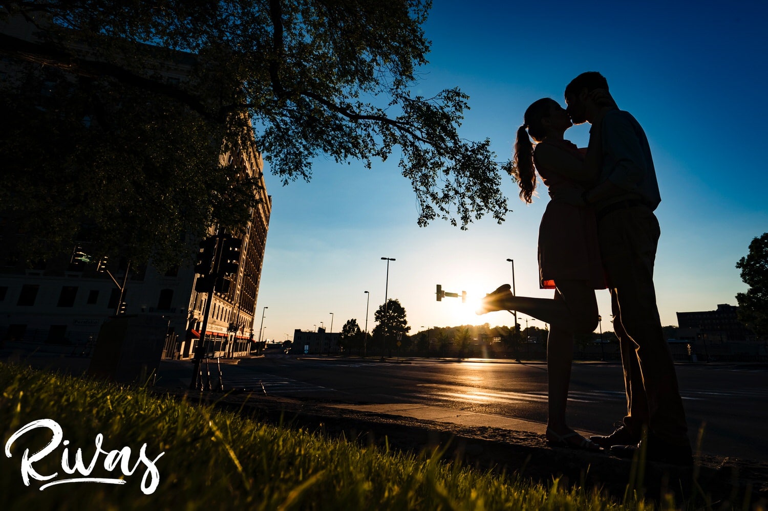 A vibrant silhouetted picture of an engaged couple sharing a kiss as the sun sets behind them during their Kansas City engagement session. 