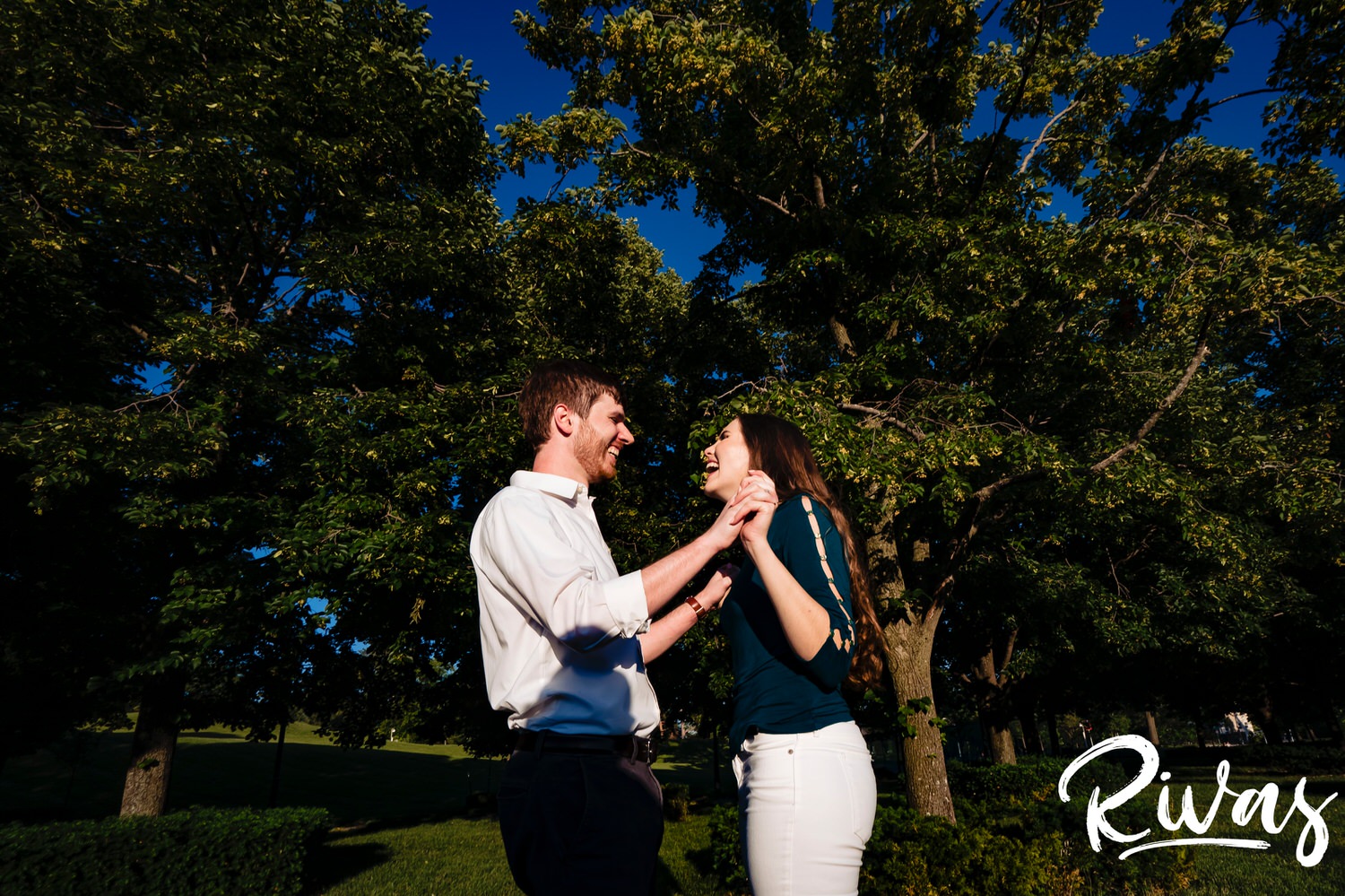 A colorful, candid picture of an engaged couple laughing and jumping together during their engagement session in Kansas City. 