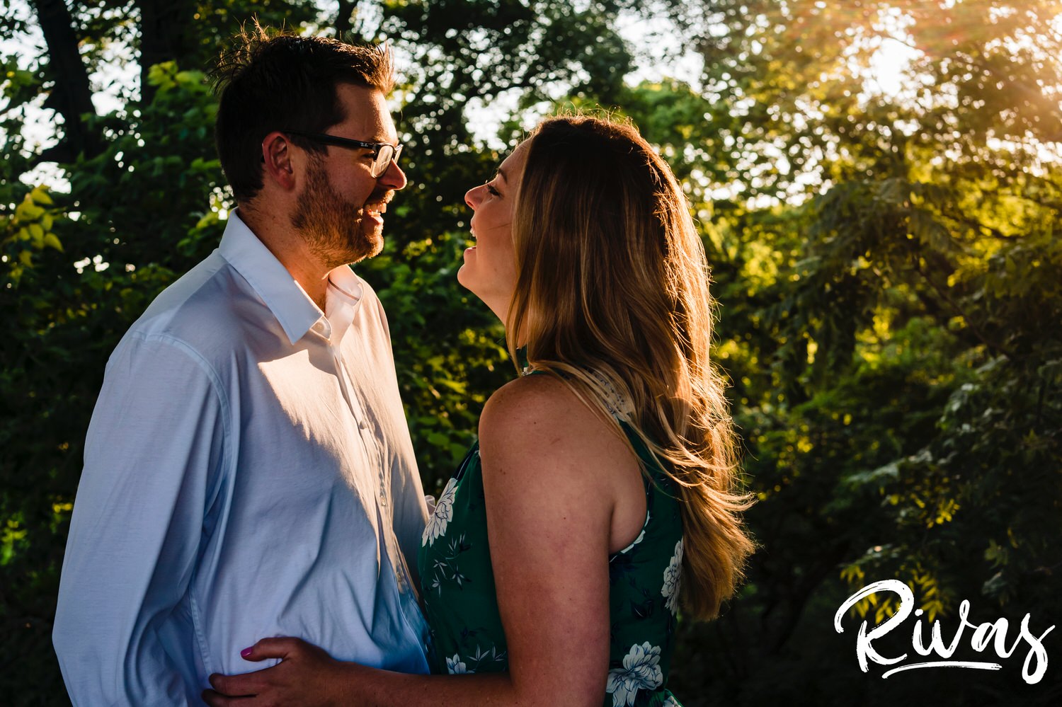 A warm, intimate picture of an engaged couple laughing together during their summer engagement session in Kansas City. 