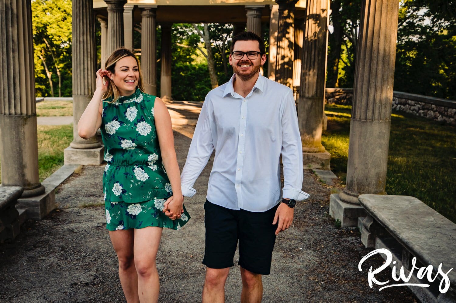 A colorful, candid picture of an engaged couple walking hand-in-hand down a path during their summer engagement session with their wedding photographer in Kansas City. 