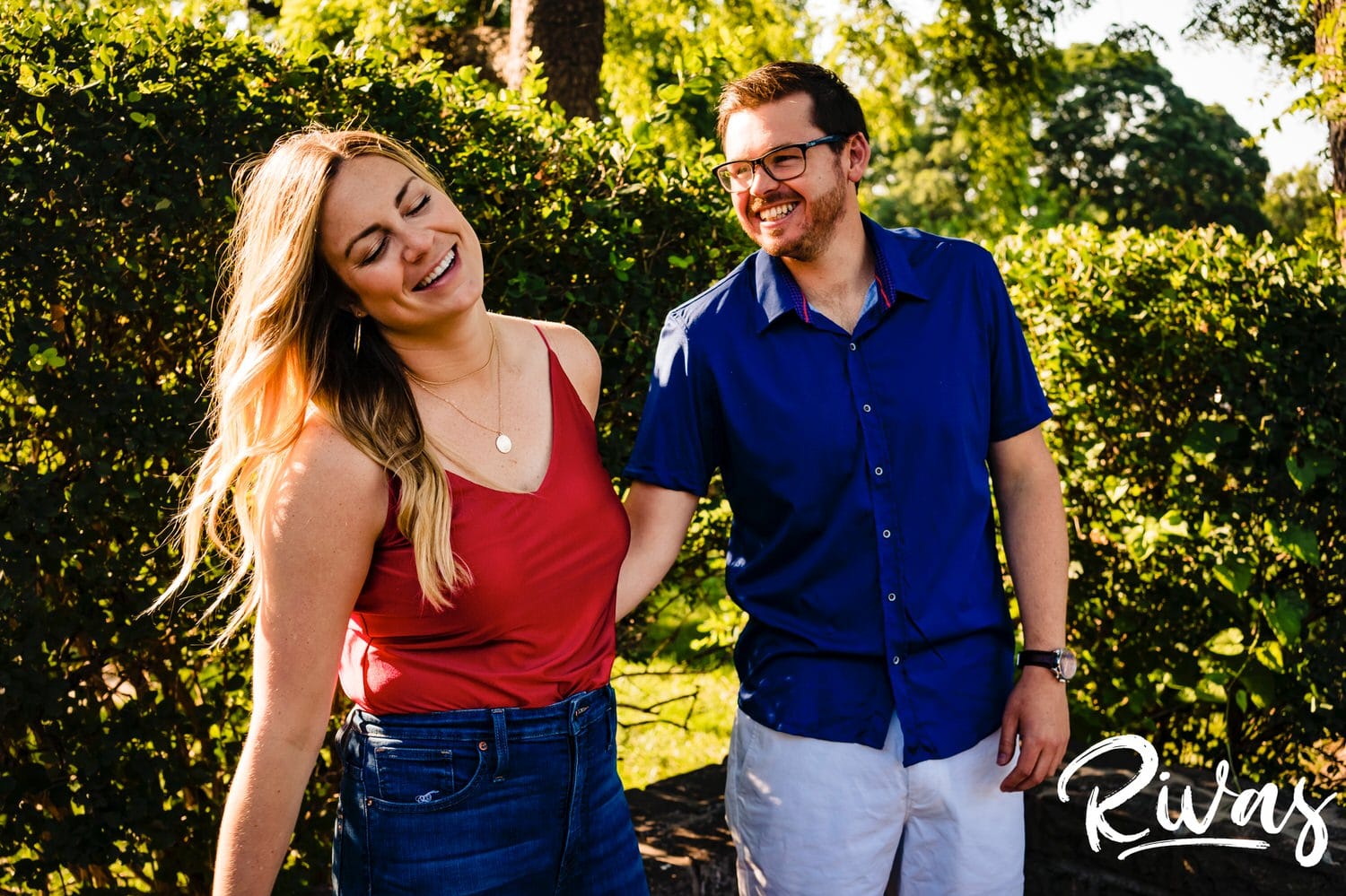A colorful, candid picture of an engaged couple laughing together during their summer engagement session with a wedding photographer in Kansas City. 