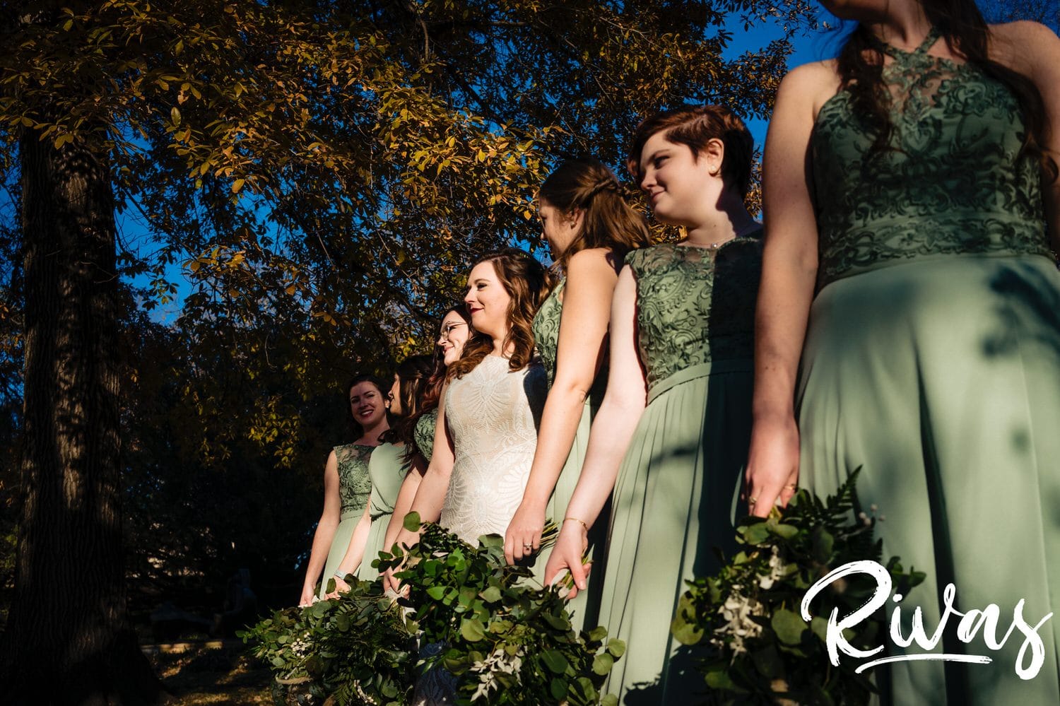 A candid picture taken from the side of a bride and her bridesmaids looking at the camera on her fall wedding day in Kansas City. 