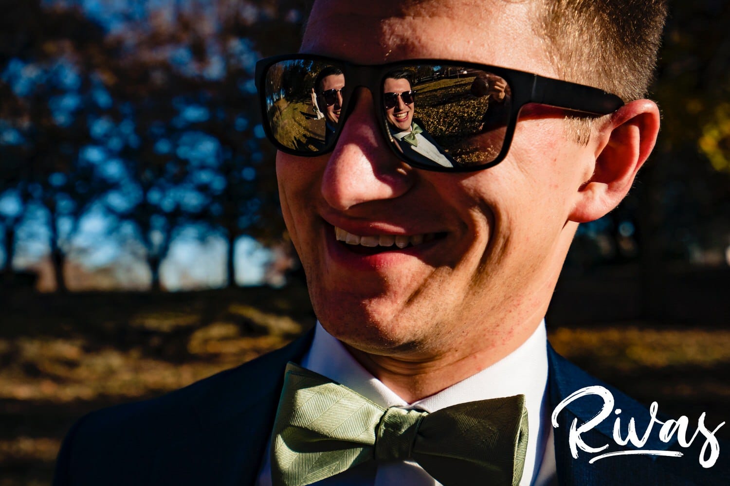 A candid reflection of a groom in the sunglasses of his best man on the afternoon of his fall wedding day in Kansas City. 
