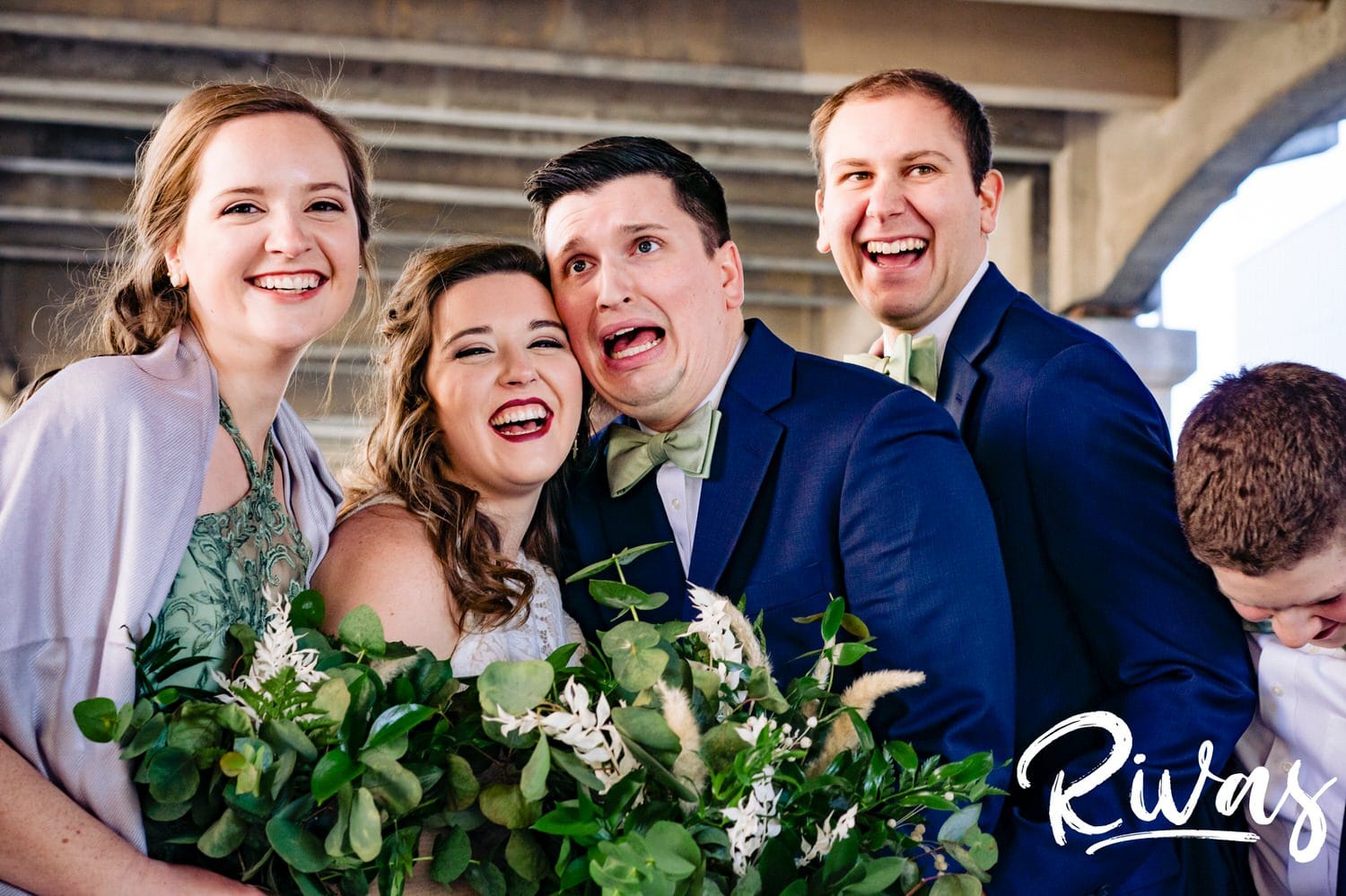 A colorful, candid picture of a groom making a horrified face as he takes wedding party pictures with his bride and wedding party on the afternoon of their fall wedding day in Kansas City. 