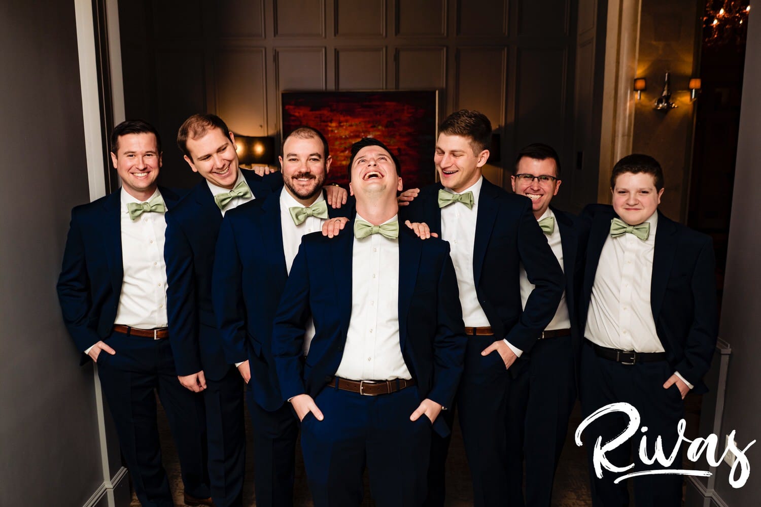 A colorful, candid picture of a groom and his groomsmen laughing hysterically as they look at the camera on a fall wedding day in Kansas City. 