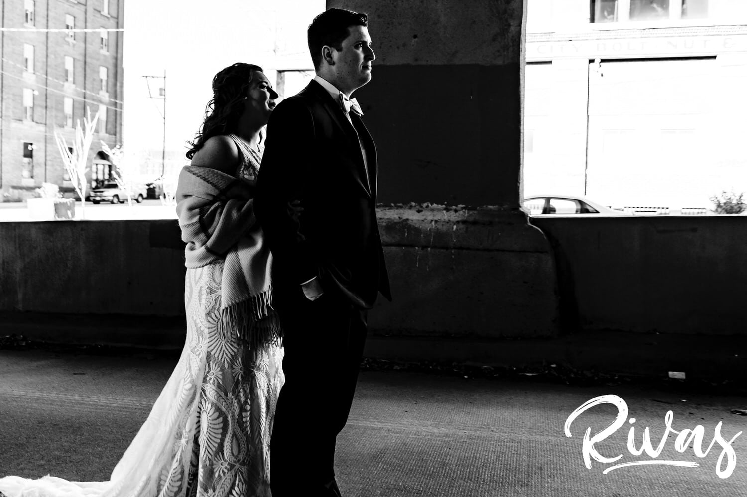 A candid black and white picture of a bride approaching her groom for their first look on the 12th Street Viaduct in Kansas City on their fall wedding day. 
