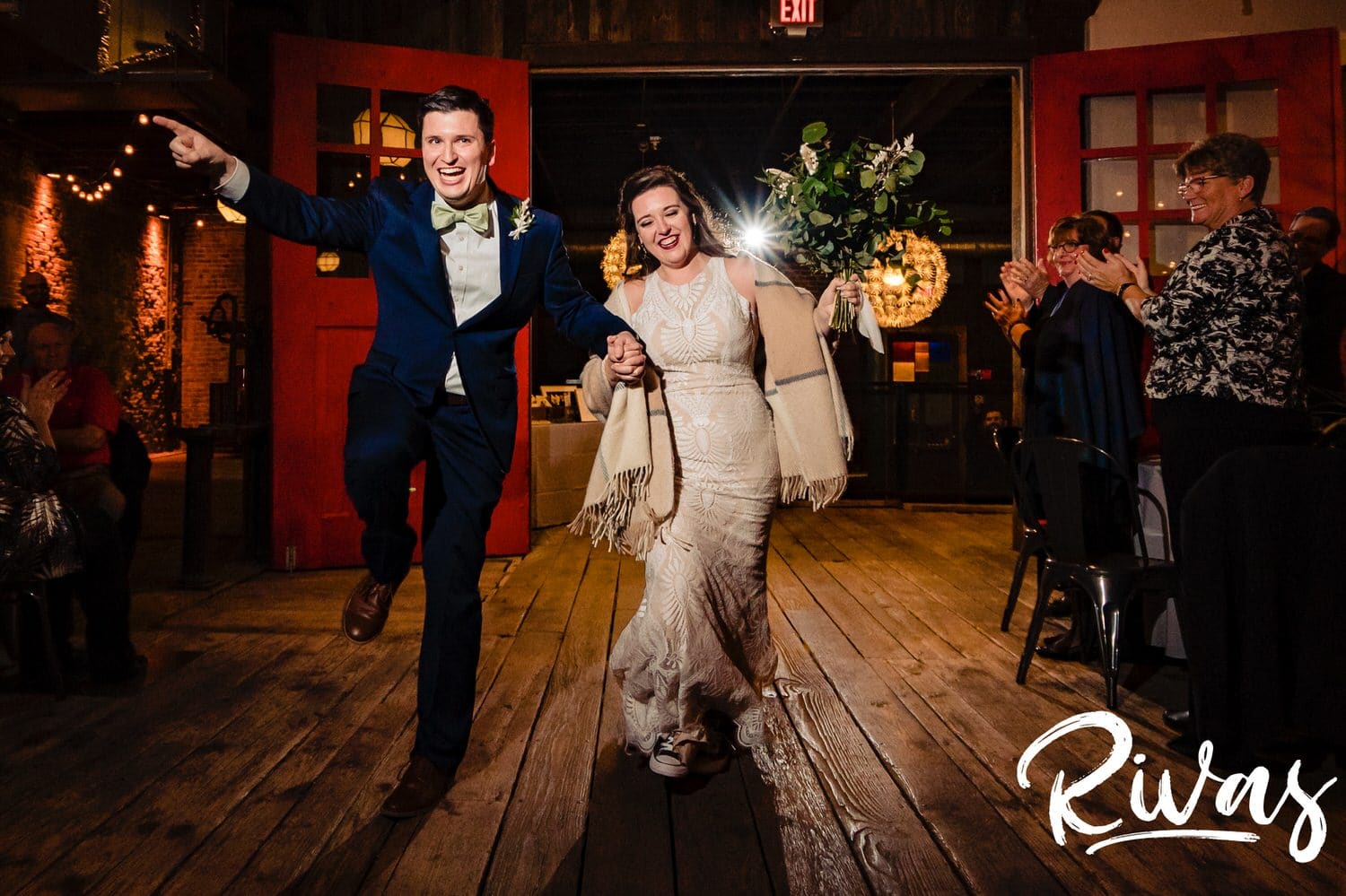A colorful, candid picture of a bride and groom excitedly running into their  fall wedding reception at The Foundation Event Space. 