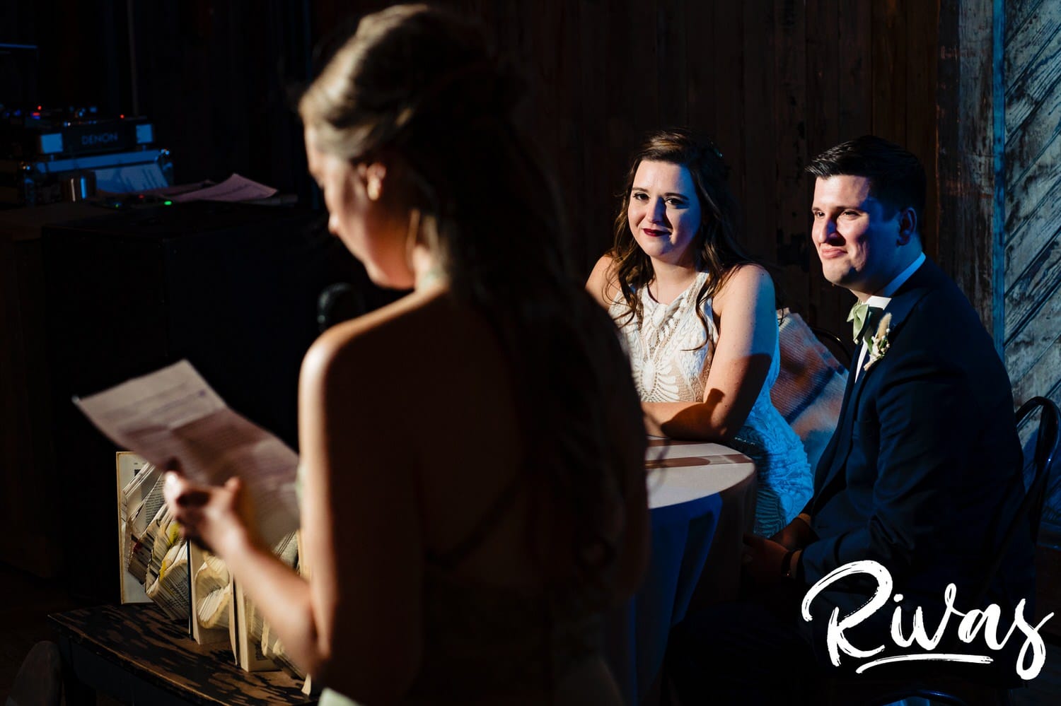 A candid picture taken over the shoulder of a bridesmaid as she toasts the bride and groom during a fall wedding reception at The Foundation event Space. 