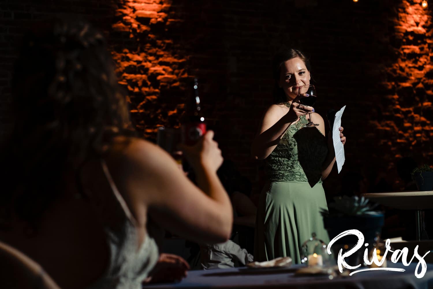 A candid picture taken over the shoulder of a bride as she is toasted during a fall wedding reception at The Foundation event Space. 