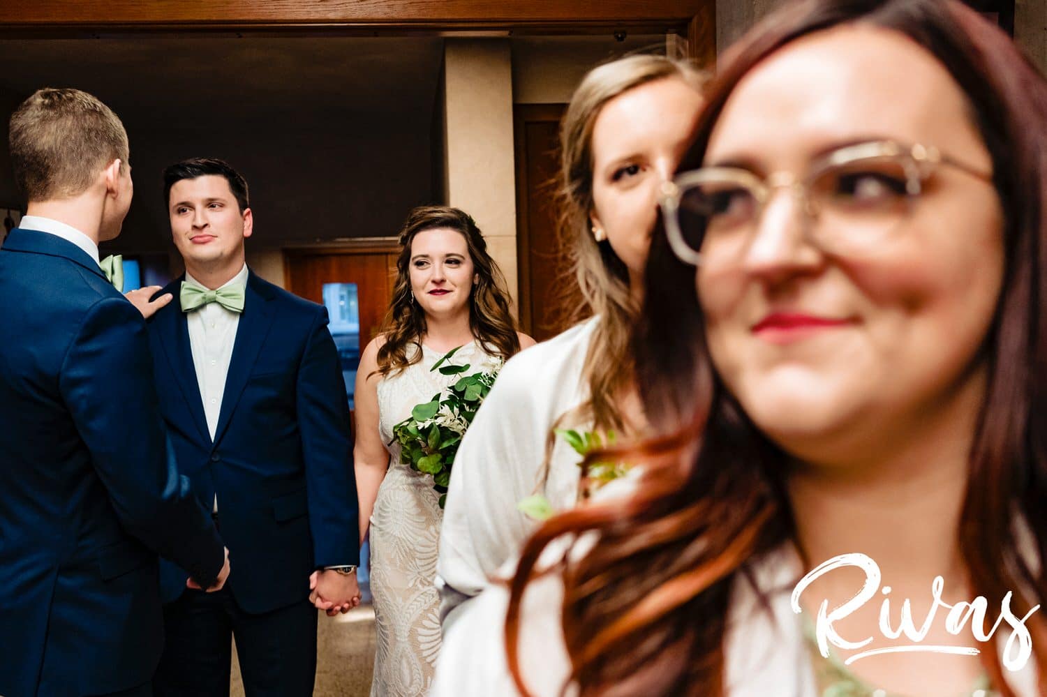 A colorful, candid picture of a groom's best man giving him last minute advice as he lines up to walk down the aisle with his bride during their fall wedding ceremony in Kansas City. 