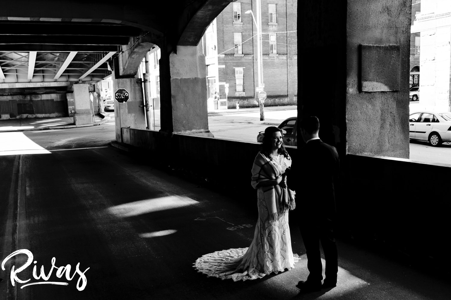 A candid picture of a bride and groom standing in a splash of sunlight as he reads his wedding vows to her on the afternoon of their fall wedding day in Kansas City. 