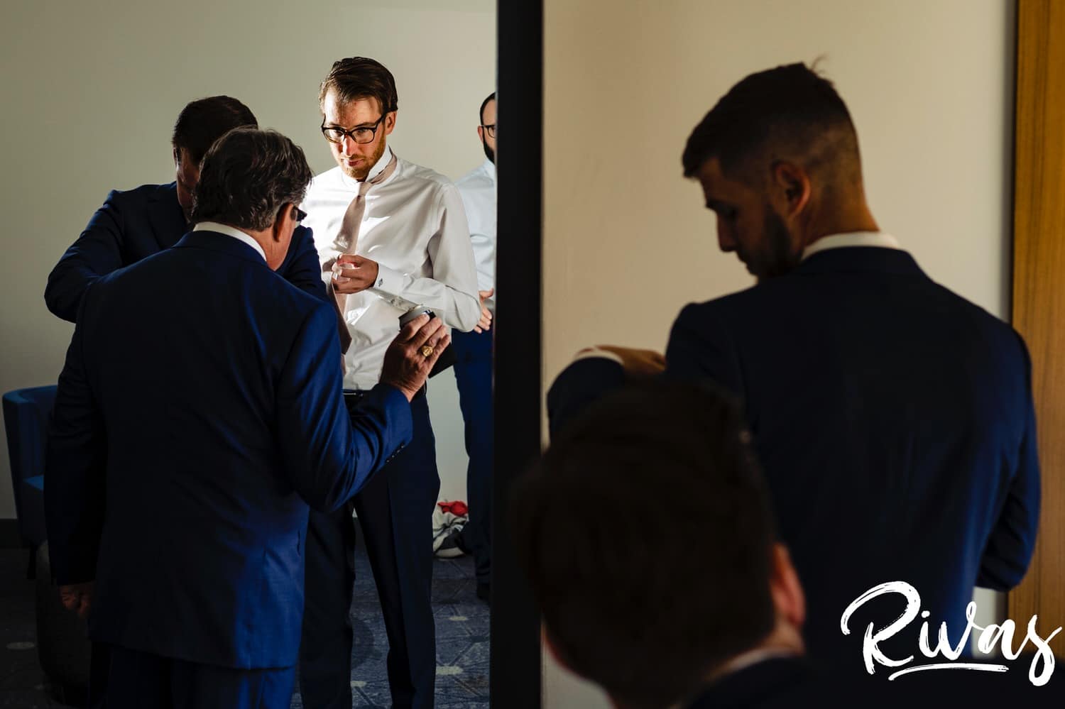 A candid picture of a groom and his groomsmen getting ready on the morning of his Museum at Prairiefire wedding reception. 