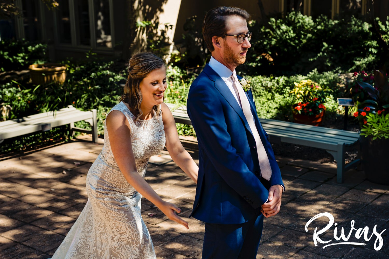 A colorful, candid picture of a bride slapping her groom's butt during their first look on their wedding day in Leawood. 