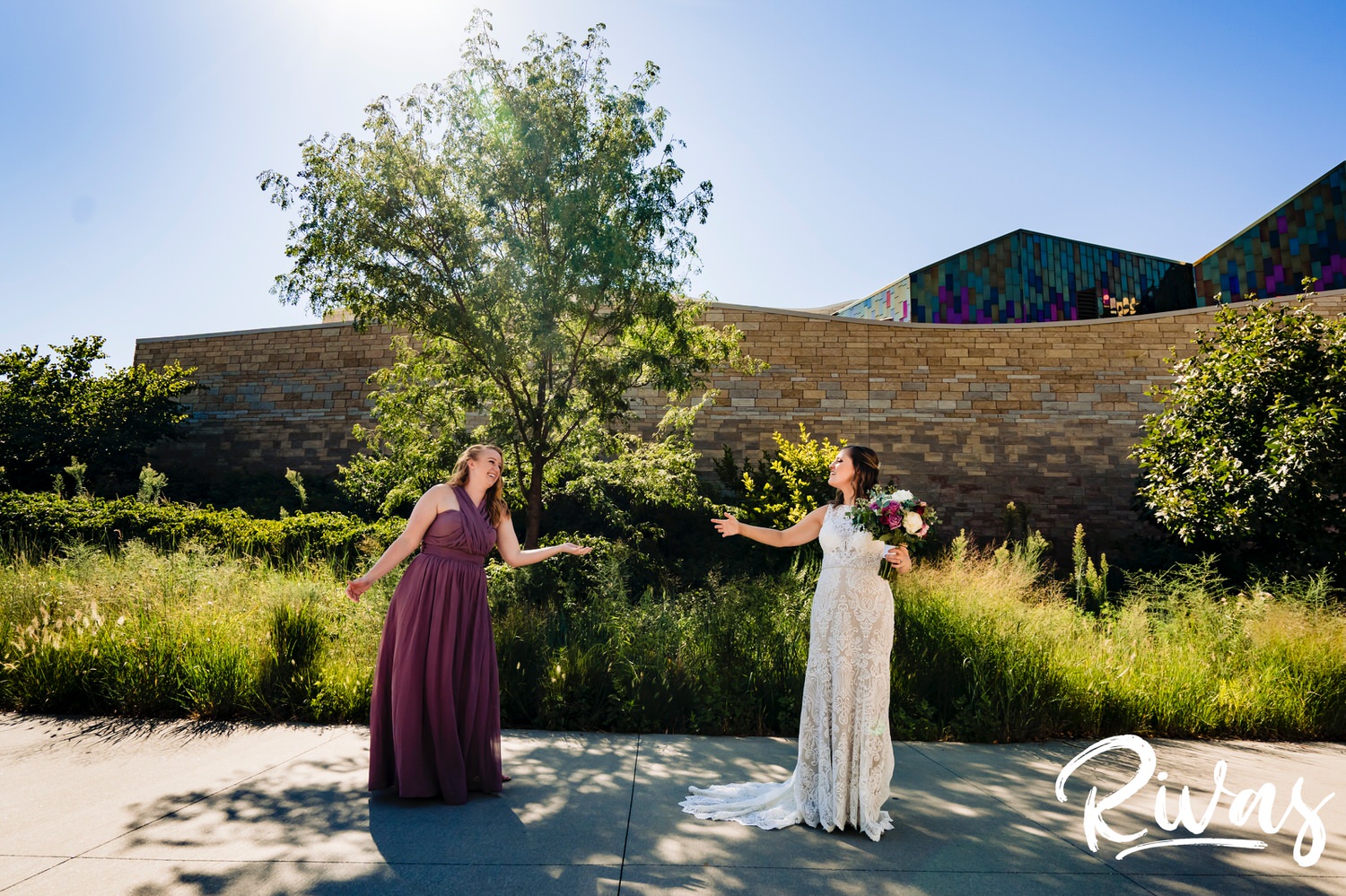 A colorful, socially distanced photo of a bride and her bridesmaids in light purple at The Museum at Prairiefire on her wedding day. 