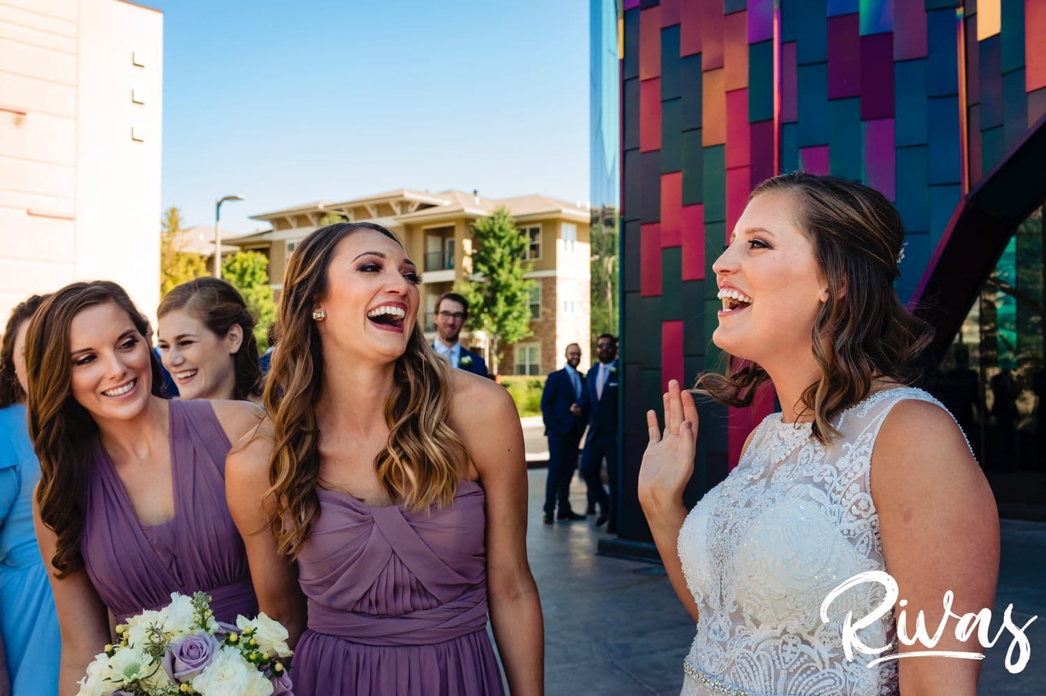 A colorful, socially distanced photo of a bride and her bridesmaids in light purple at The Museum at Prairiefire on her wedding day. 