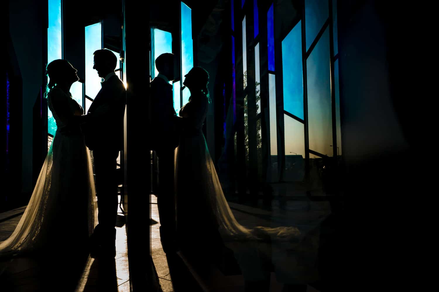 A mirrored silhouette of a bride and groom leaning in for a kiss at the Museum at Prairiefire on their 2020 KC wedding day. 