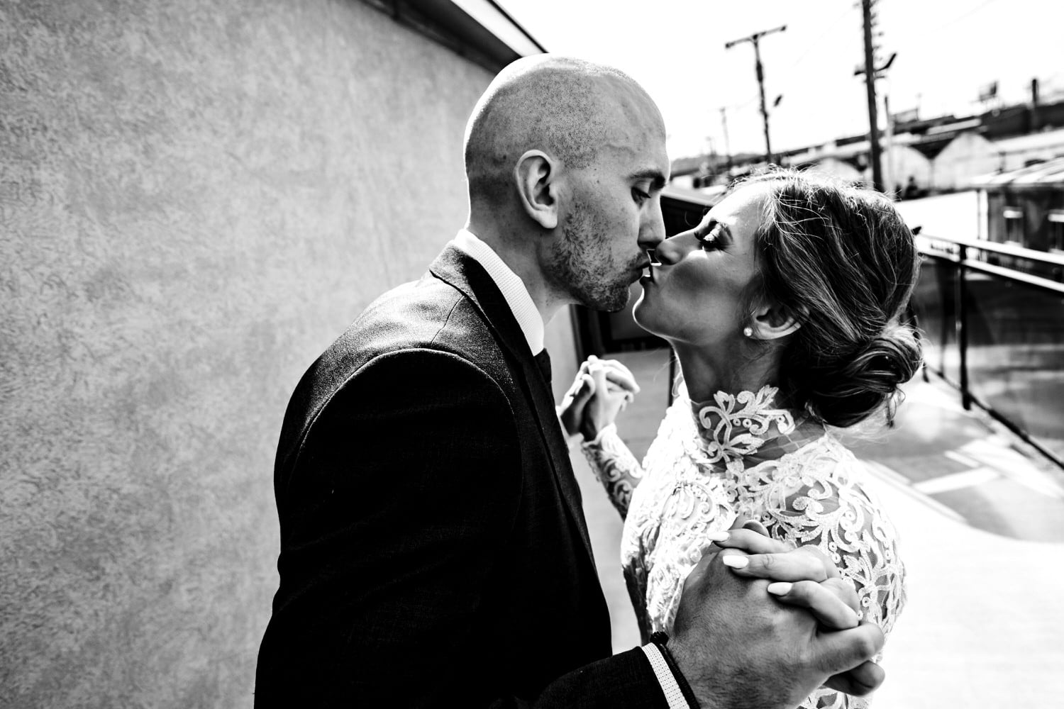 A candid black and white picture of a bride and groom leaning in to share  a kiss on their 2020 KC Wedding Day. 