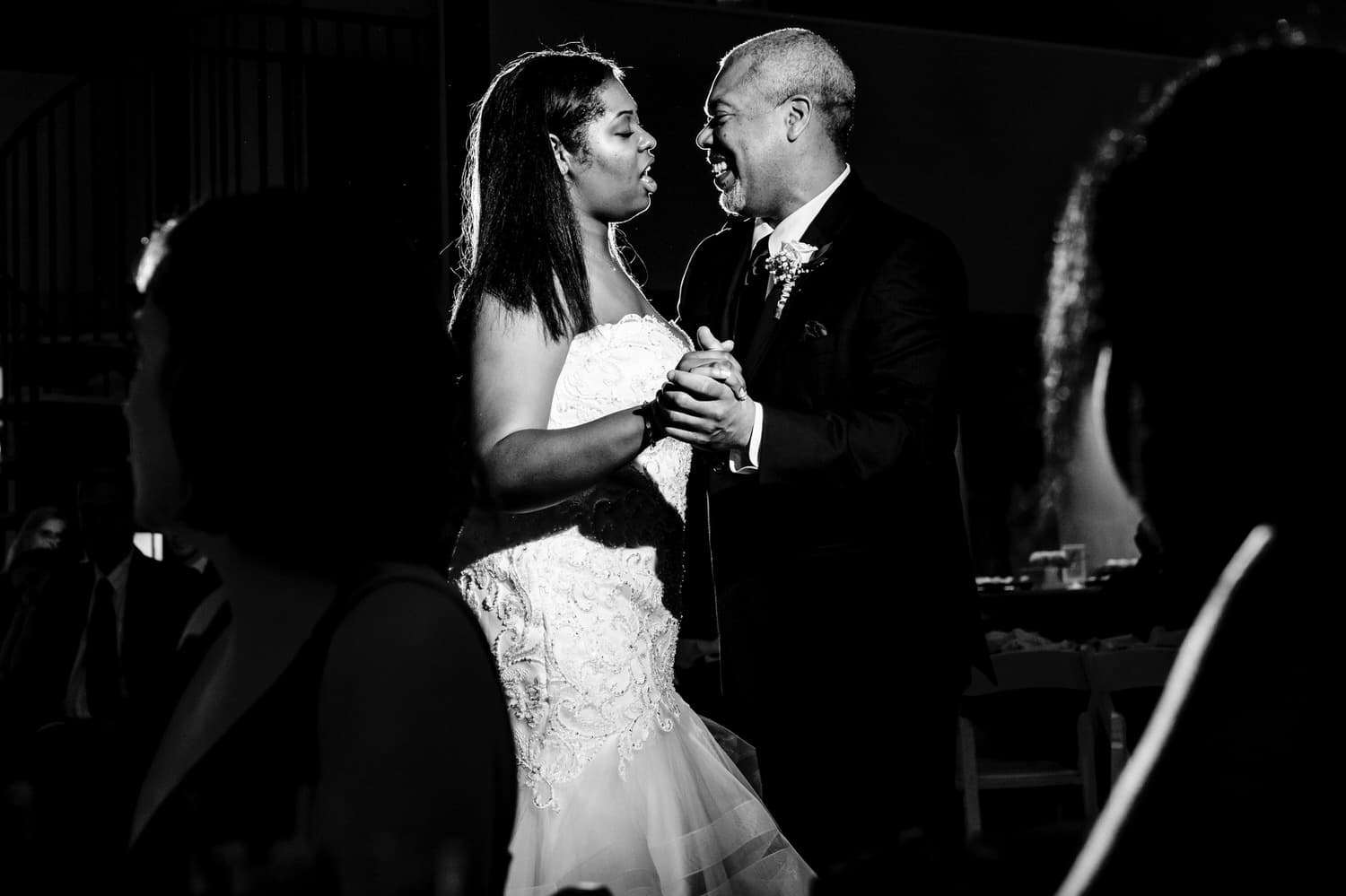 A candid black and white picture of a bride and her father dancing during a winter wedding reception at The Station in Kansas City. 