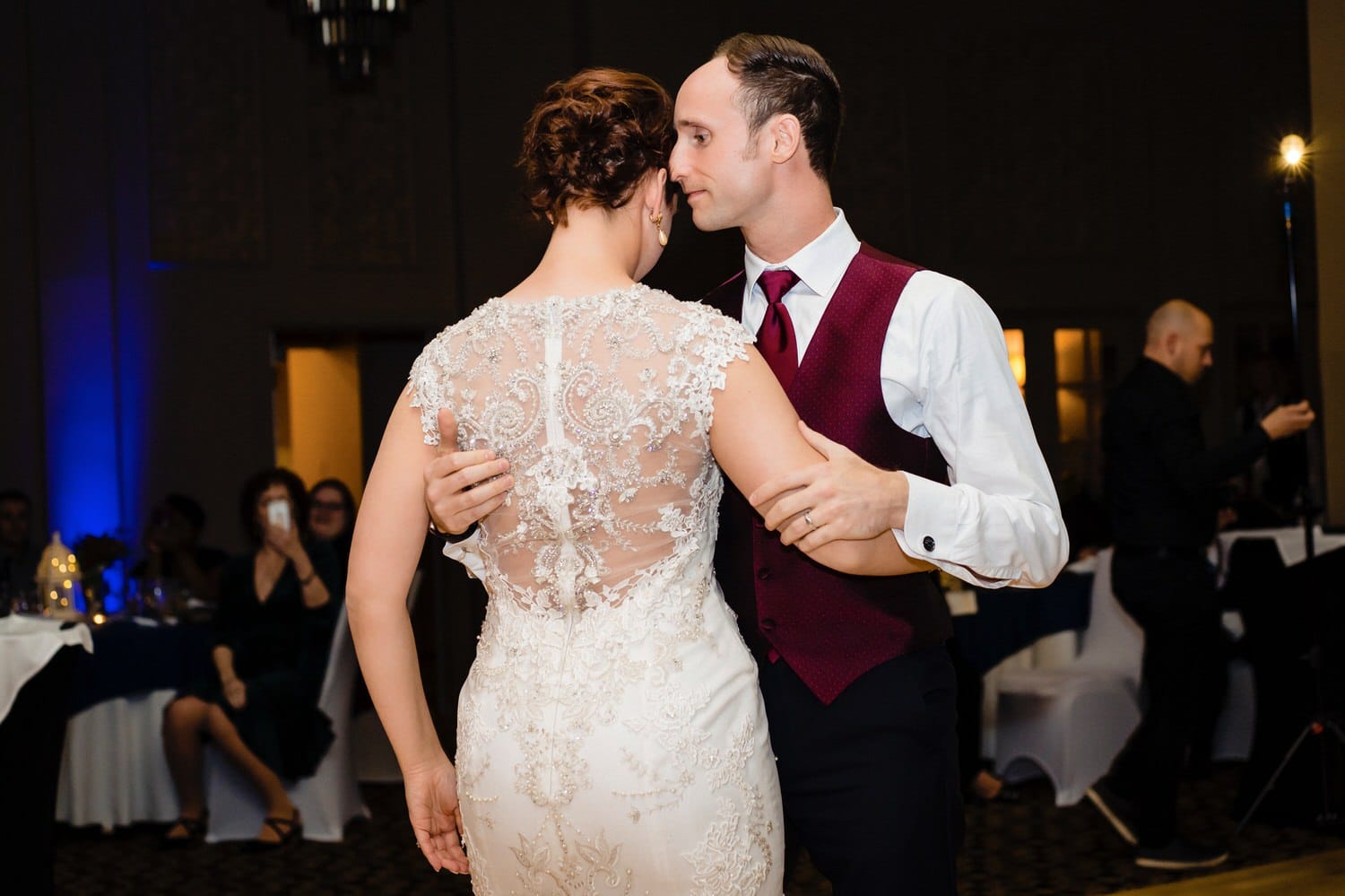 A colorful, candid picture of a groom delicately holding his bride during the waltz they do for their first dance during their wedding reception at The Elms. 