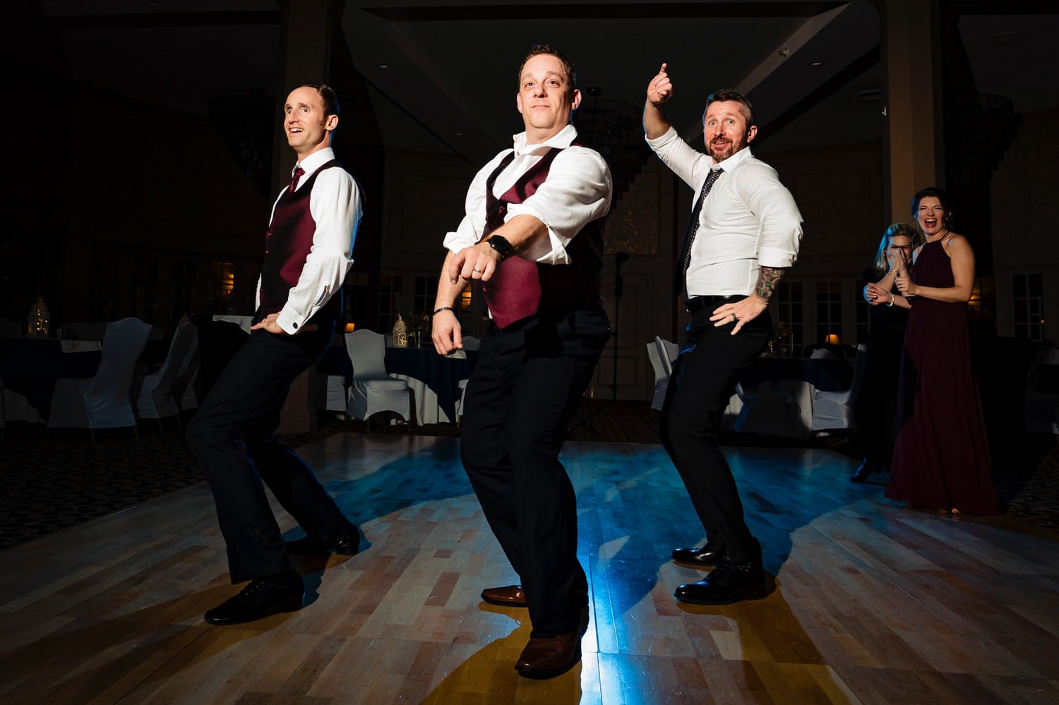 A colorful, candid picture of a groom and his groomsmen dancing wildly on the dance floor during a winter wedding reception at The Elms. 