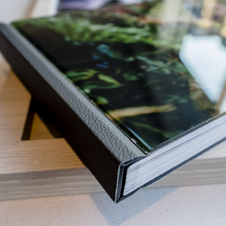 A picture of a leather-bound wedding album sitting on top of a wooden box.
