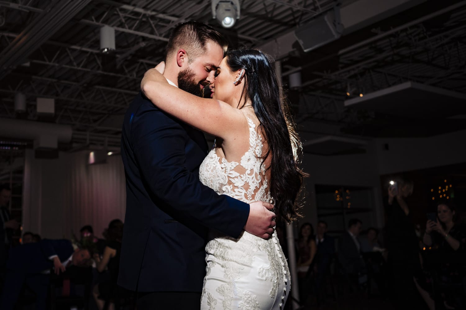 An up-close, intimate photo of a bride and groom sharing their first dance, their foreheads pressed together during their wedding reception at Pennway Place in Kansas City. 