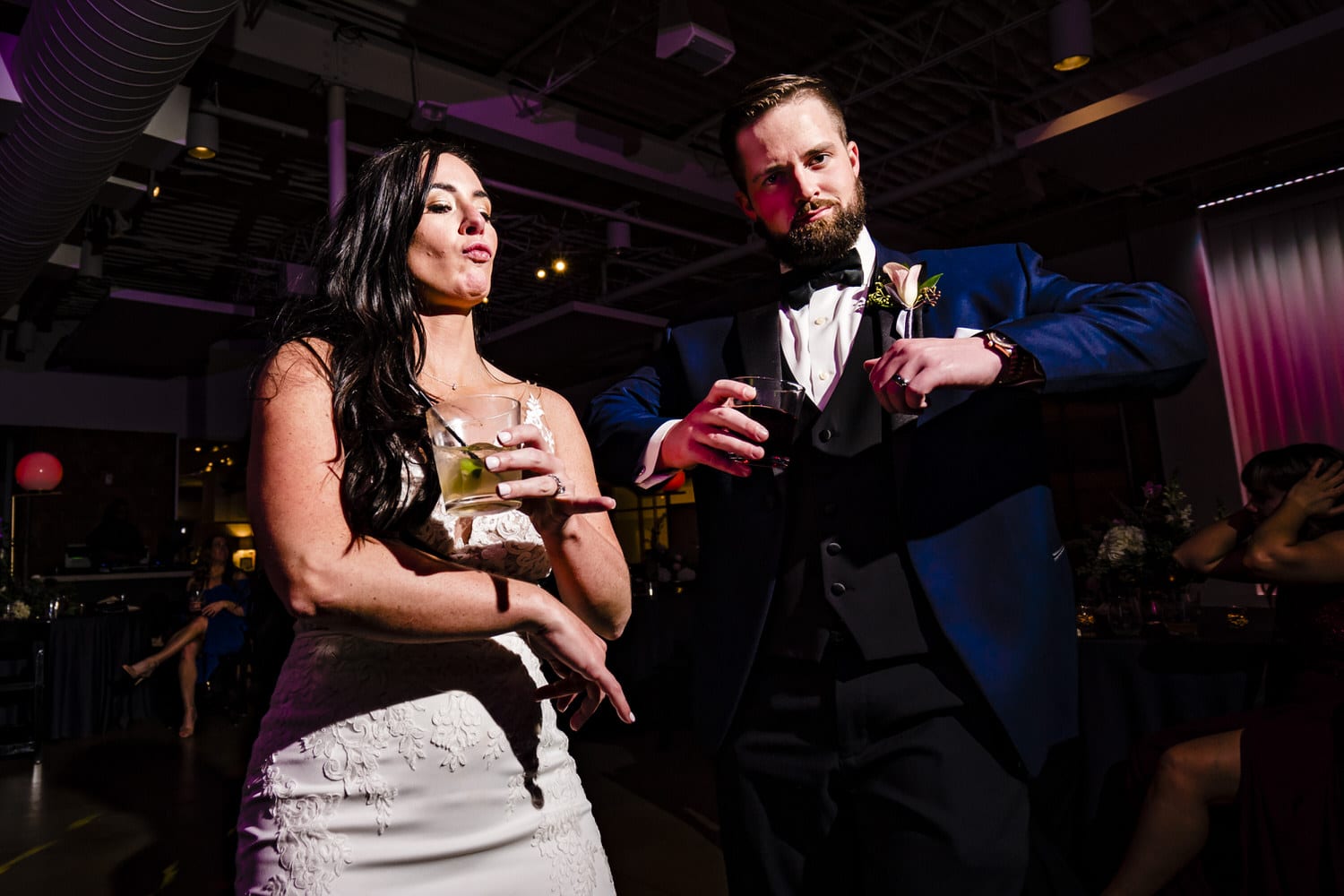A canid, colorful picture of a bride and groom dancing with wedding guests during a wedding reception at Pennway place in Kansas City. 