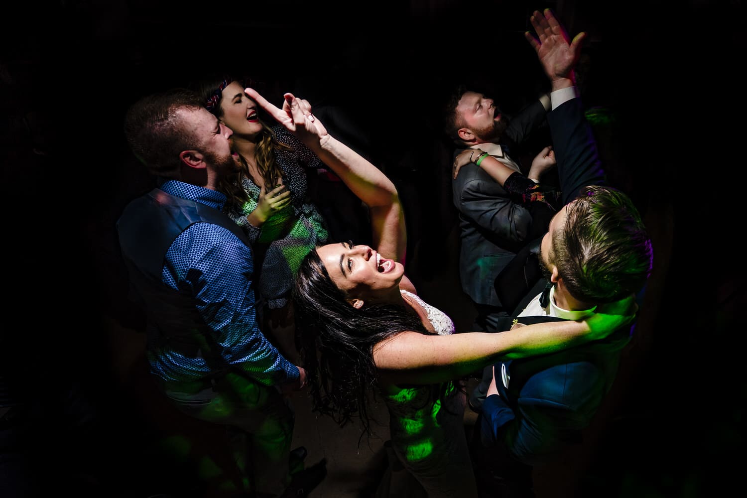 A canid, colorful picture of a bride and groom dancing with wedding guests during a wedding reception at Pennway place in Kansas City. 