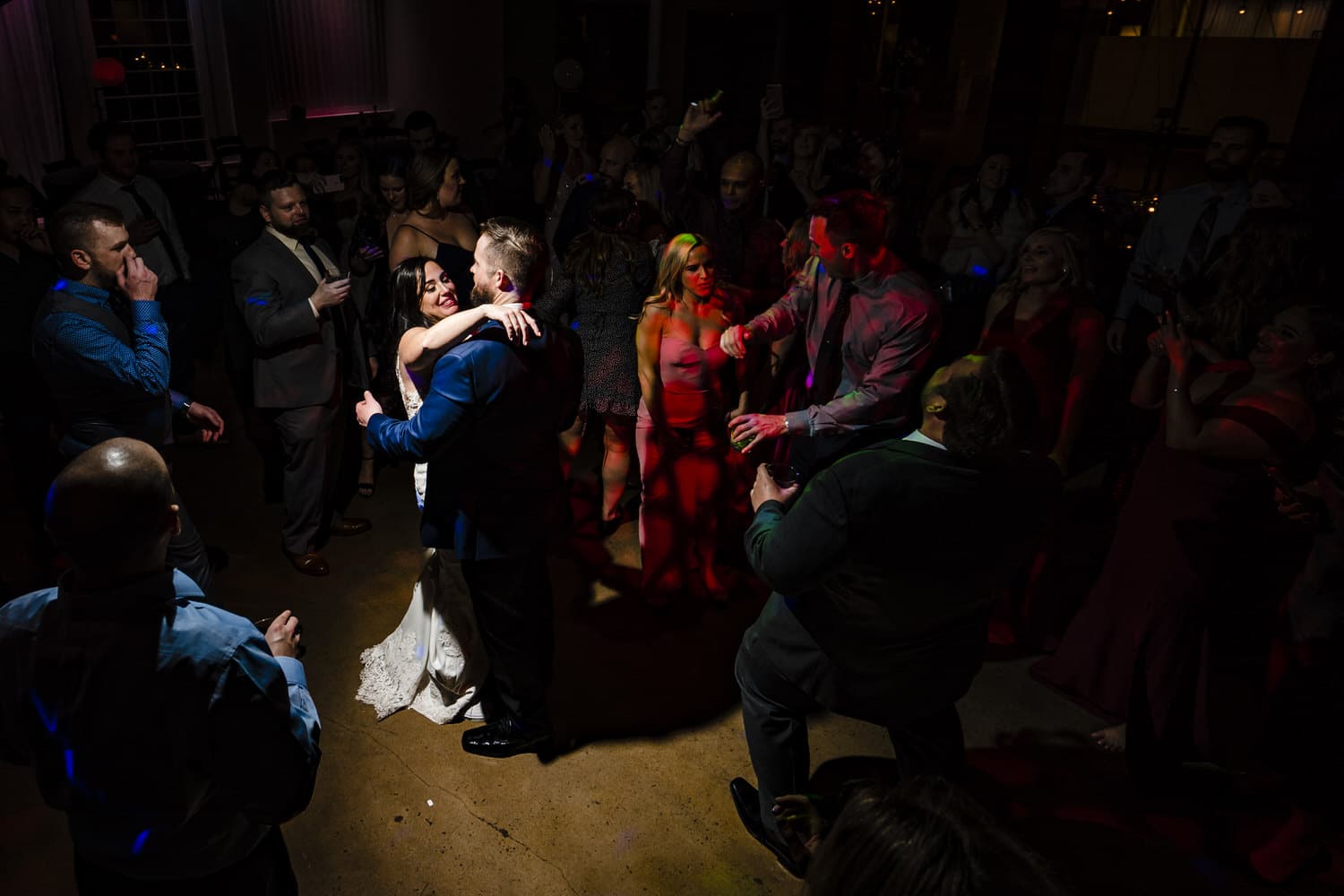 A picture of wedding guests excitedly and enthusiastically dancing and singing along to the music during a wedding reception at Pennway Place in Kansas City. 
