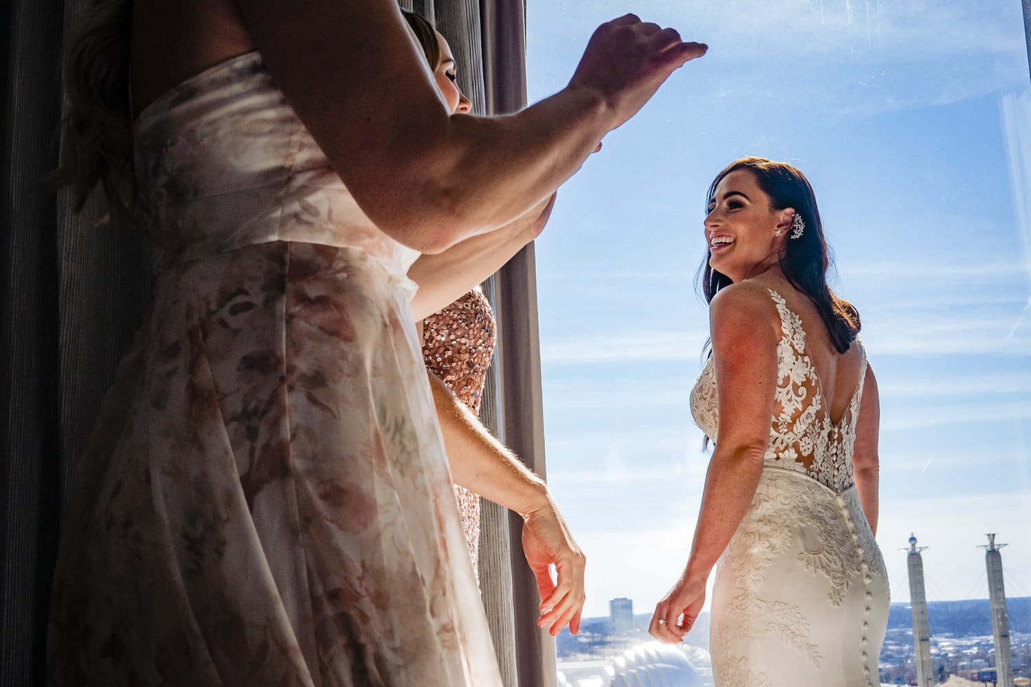 A colorful, candid picture of a bride laughing as her bridesmaids gesture enthusiastically with their hands. 