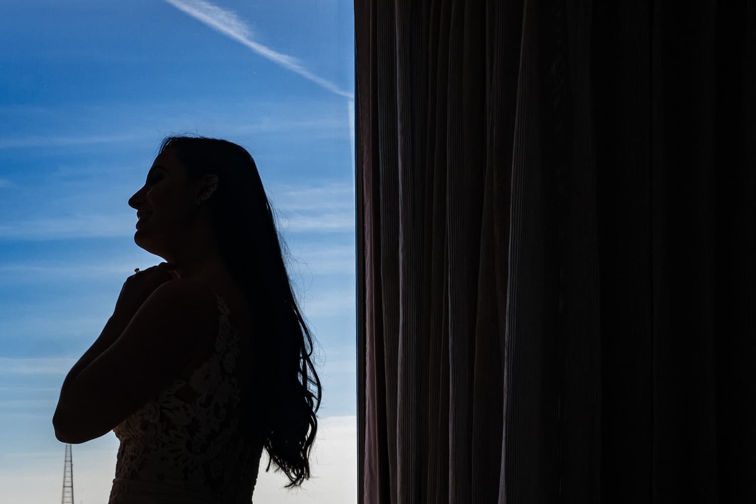 A colorful picture of a silhouetted bride on the morning of her winter wedding in Kansas City. 