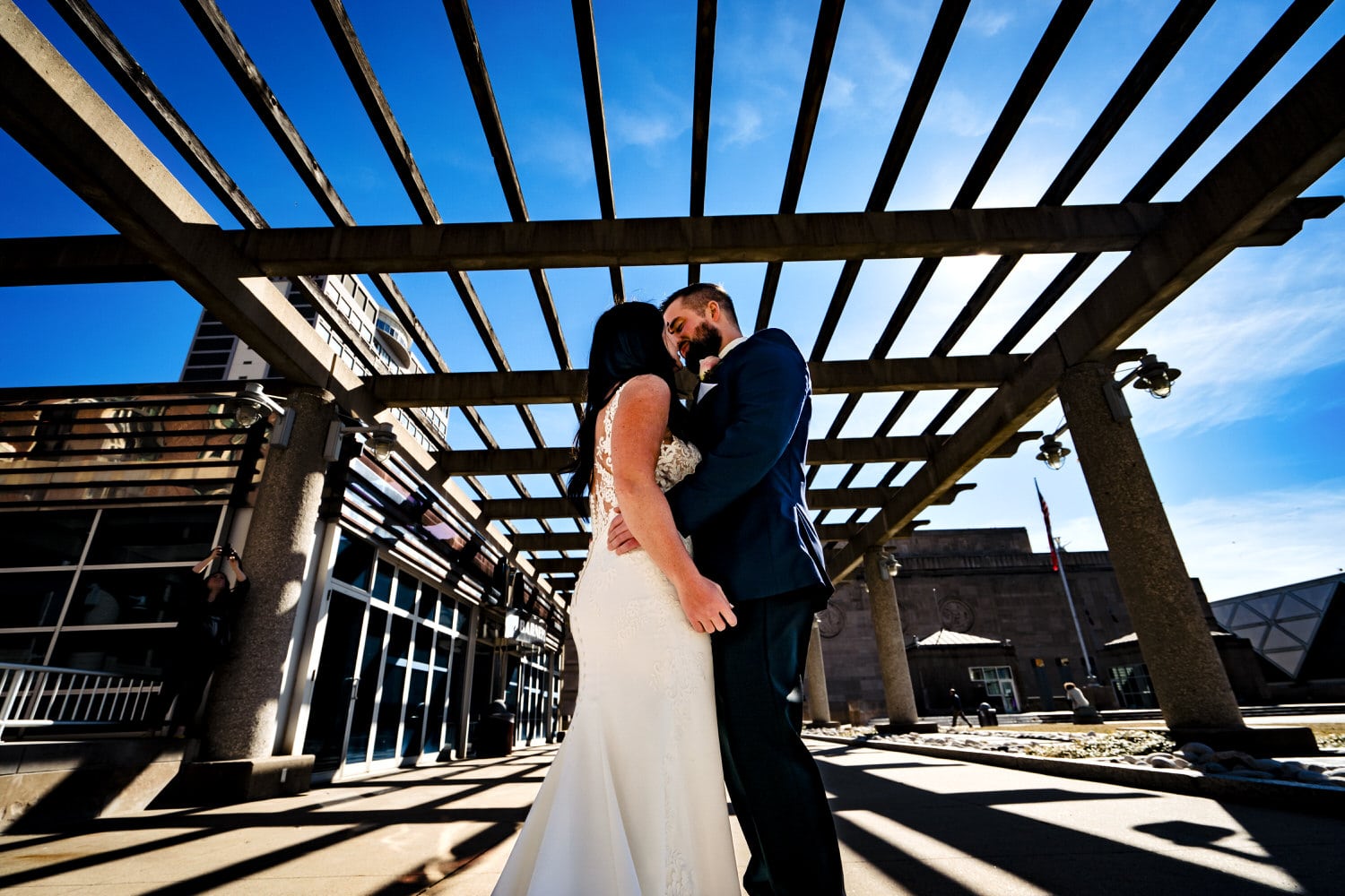 A colorful picture taken from the ground looking up of a bride and groom embracing during their first look on their winter wedding day in Kansas City. 