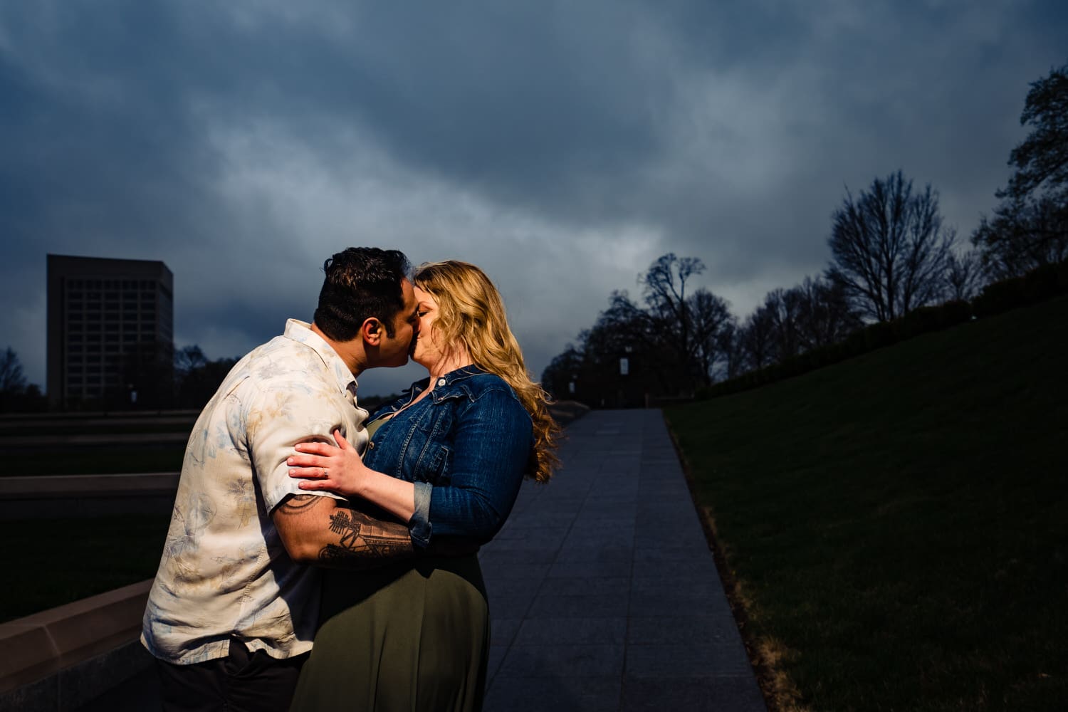 A candid picture of an engaged couple sharing a kiss during their downtown Kansas City engagement session at Liberty  Memorial. 