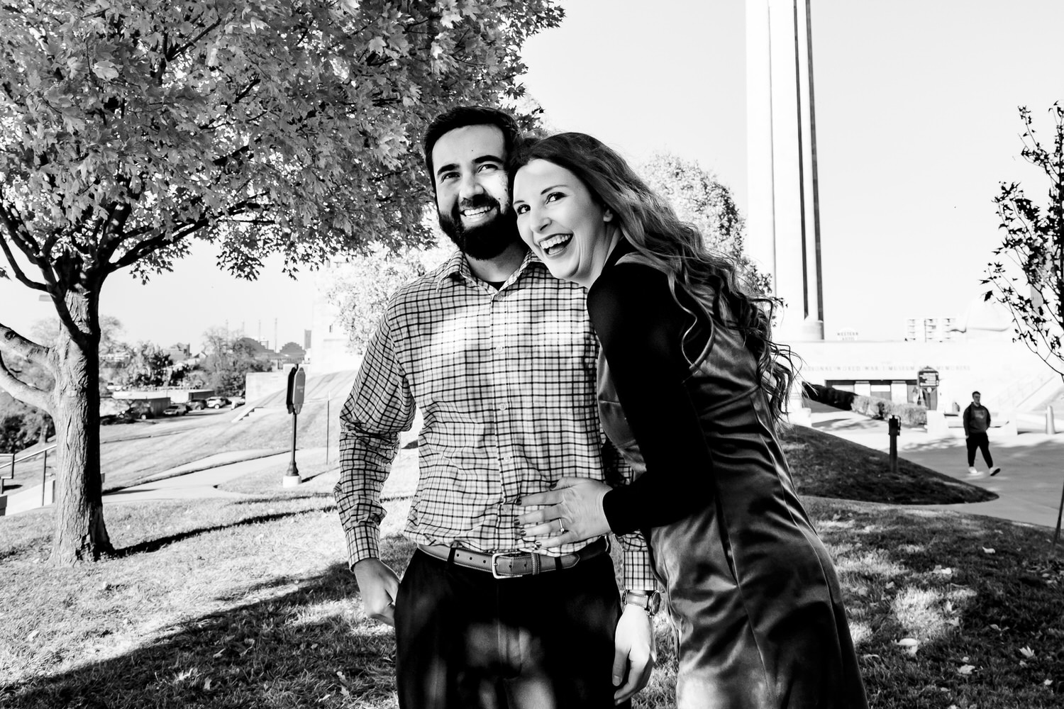 A candid black and white picture of an engaged couple laughing together during their engagement session at Liberty Memorial. 