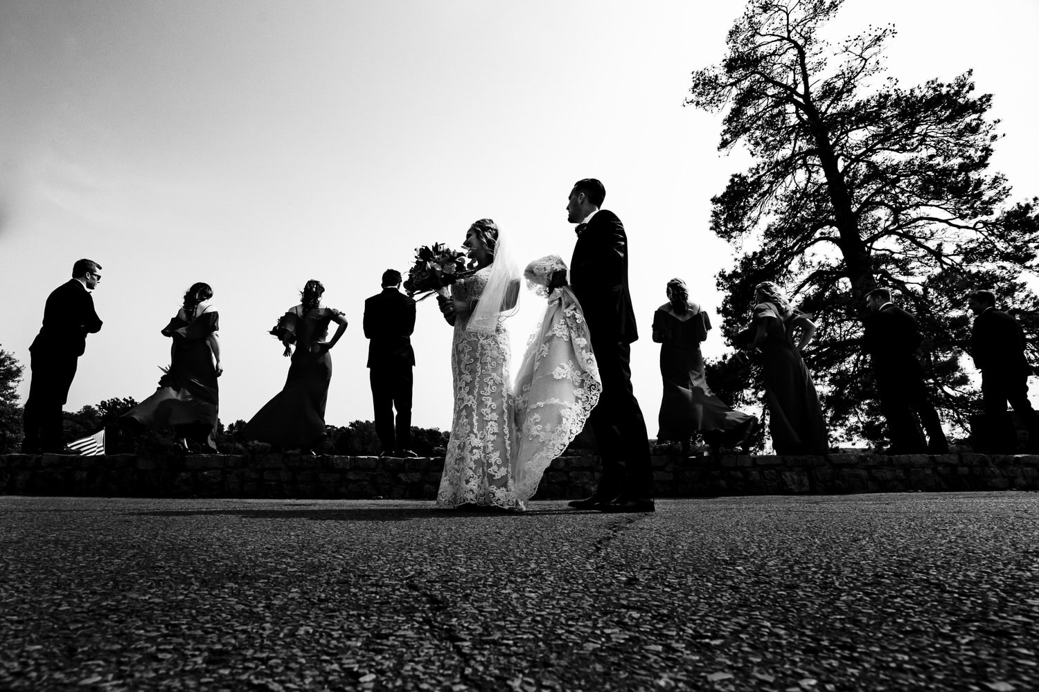 A candid black and white picture of a bride and groom with their wedding party on a fall wedding day at Lake Quivira Country Club in Kansas City. 