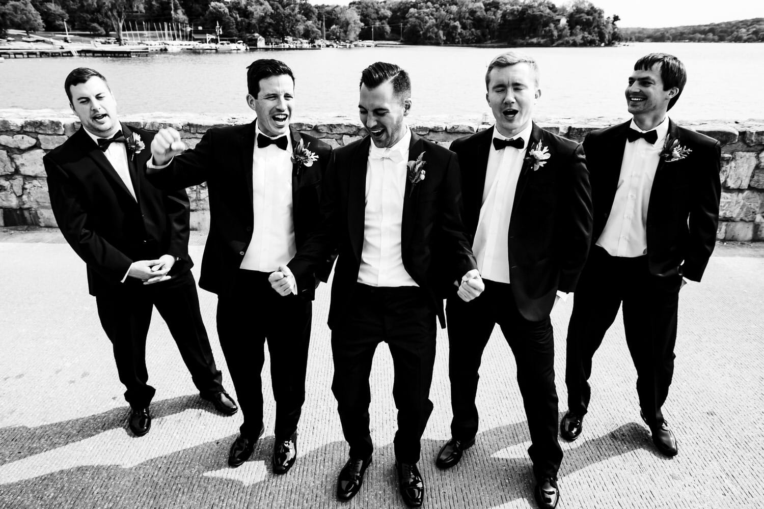 A candid black and white picture of a groom and his groomsmen on a fall wedding day at Lake Quivira Country Club in Kansas City. 