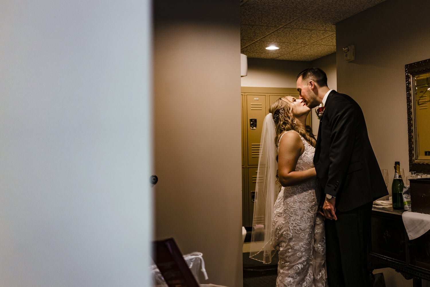 A candid picture of a bride and groom sharing a kiss moments before their fall wedding ceremony at Lake Quivira Country Club in Kansas City. 