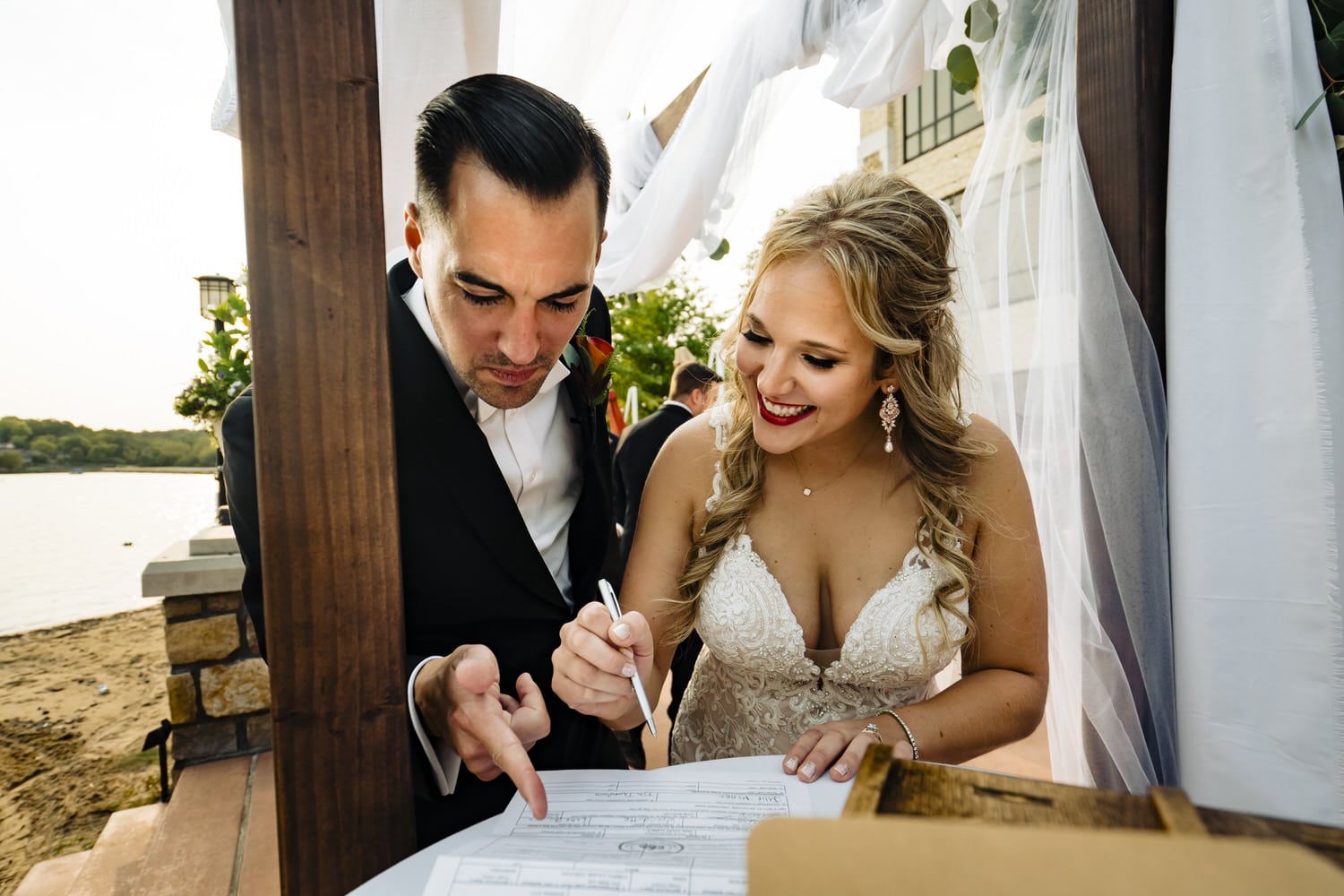 A candid picture of a bride and groom double checking the details on their marriage license during a wedding ceremony at Lake Quivira Country Club in Kansas City. 