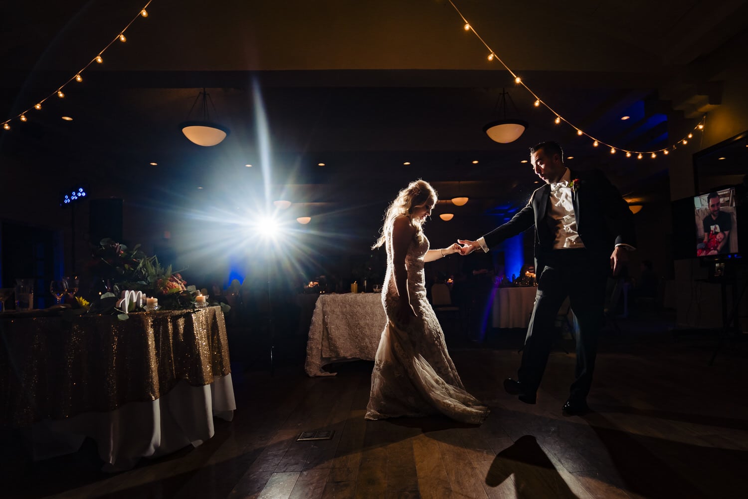 A colorful, candid picture of a bride and groom sharing their first dance during a wedding reception at Lake Quivira Country Club. 