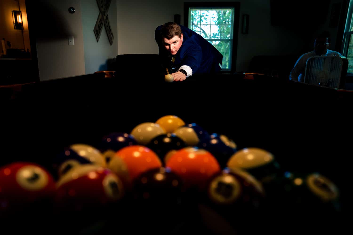A colorful picture of a man breaking a group of pool balls. 