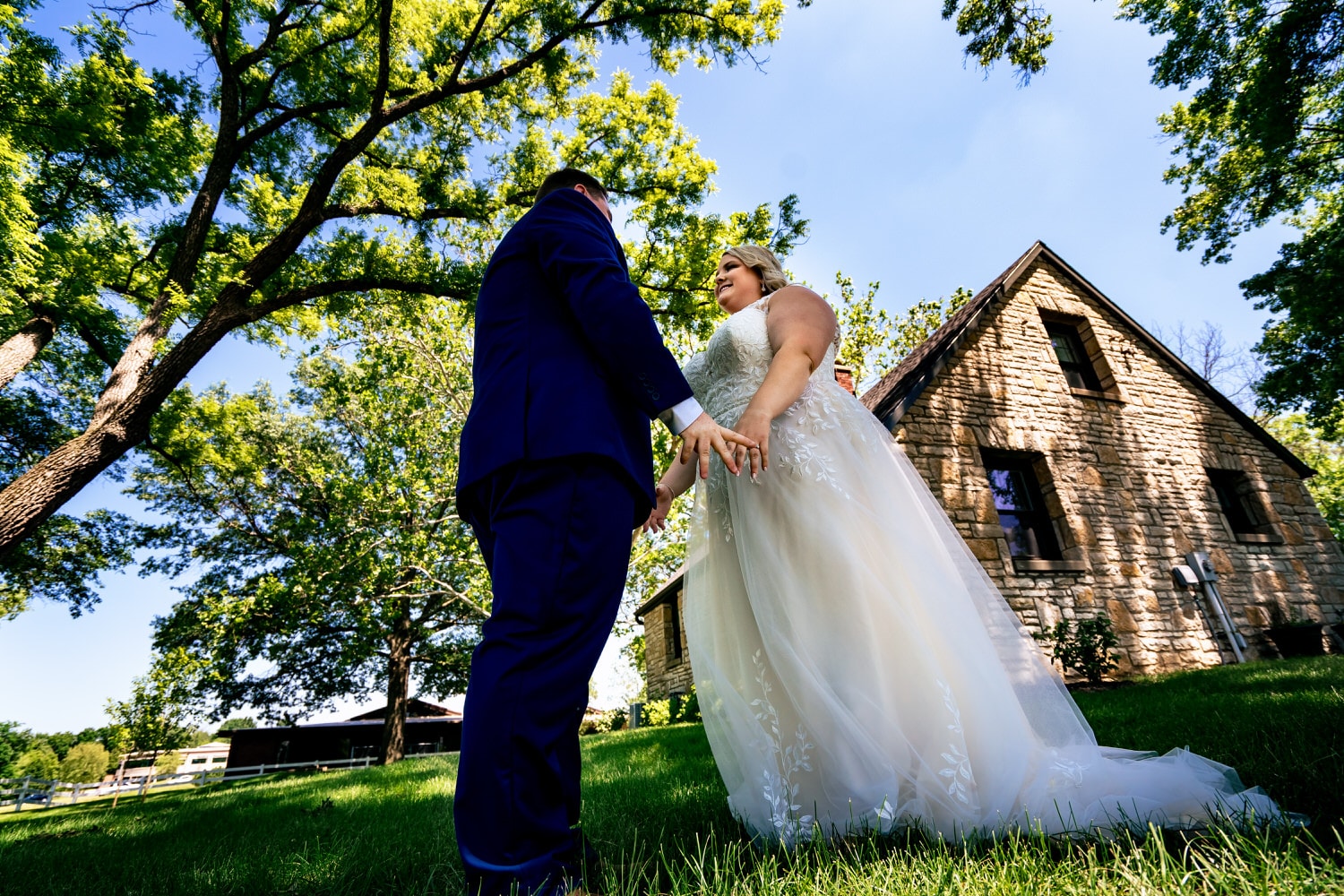 A colorful picture of a groom seeing his bride for the first time on their summer wedding day at The Farmhouse KC Event Venue. 