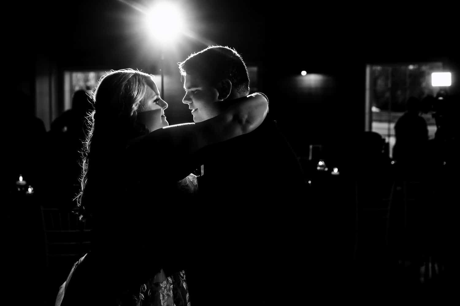 A wide, candid picture of a bride and groom sharing their first dance during a summer wedding reception at The Farmhouse KC Event Venue in Kansas City. 