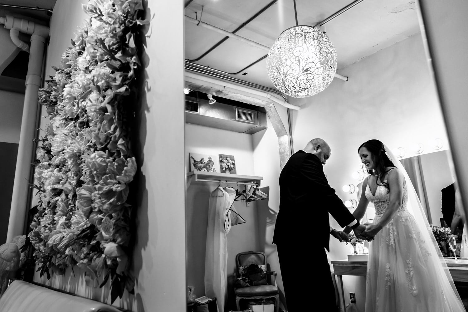 A candid black and white picture of a bride and groom holding hands, looking each other up and down on the day of their summer wedding at The Bauer in Kansas City. 