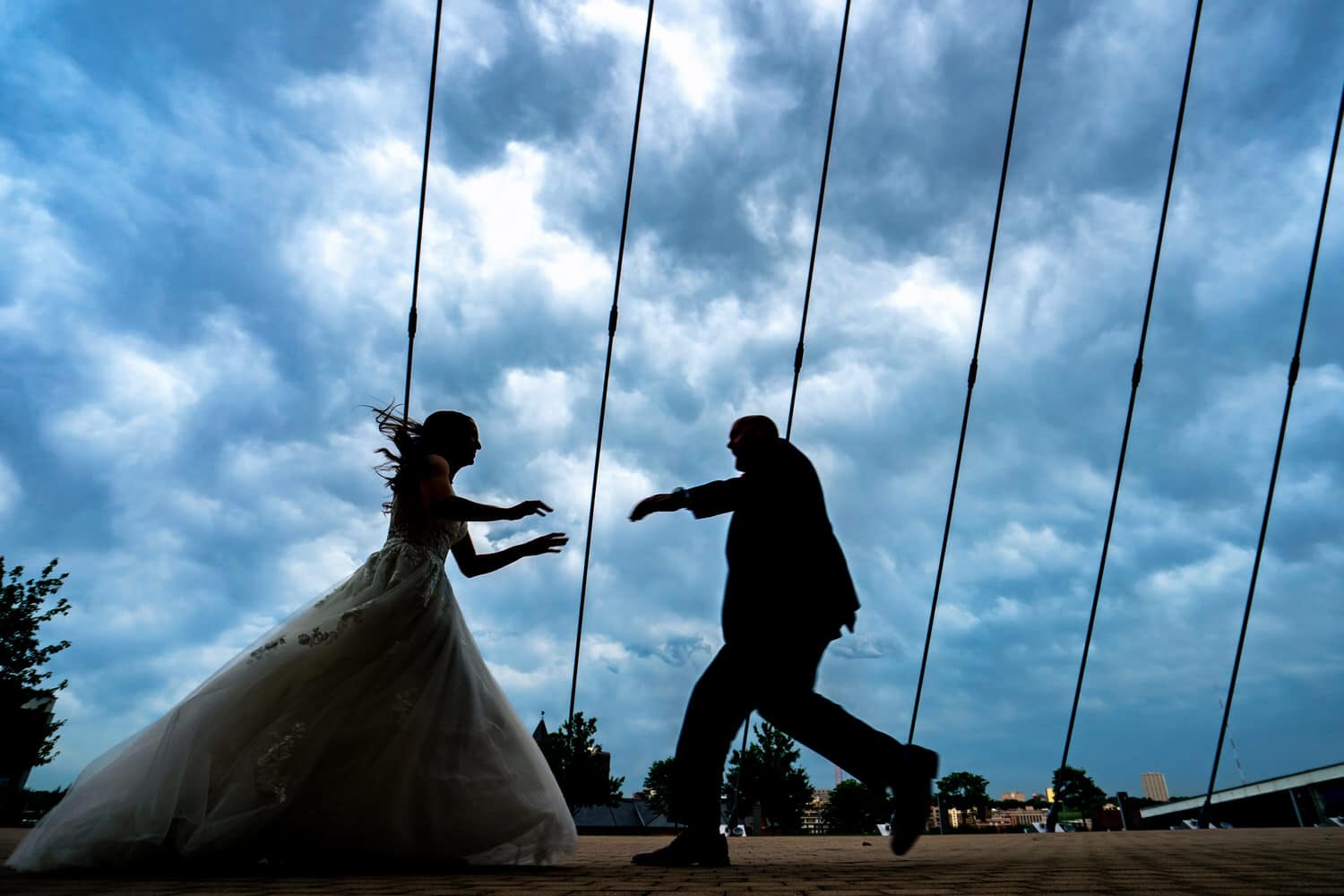 A candid, colorful picture of a bride and groom, their arms outstretched and reaching for each other, running towards each other. 