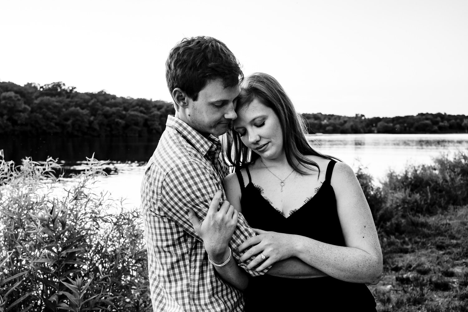 A black and white portrait of an engaged couple sharing an embrace during their summer engagement session in Kansas City. 