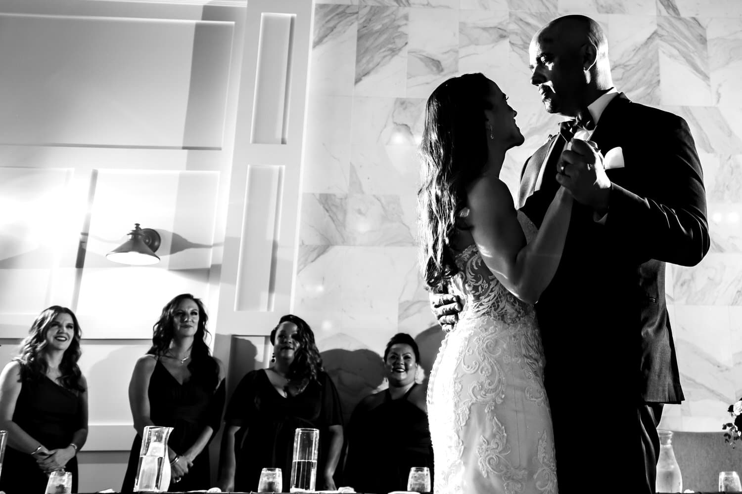 A candid black and white picture of a bride and groom sharing their first dance on their timeless summer wedding day at The Station in Kansas City. 