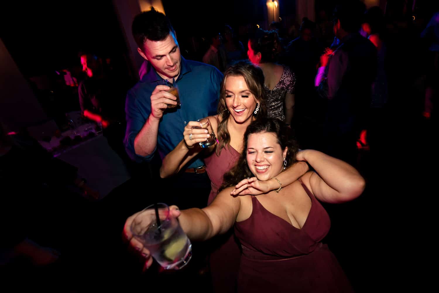 A colorful, candid picture of wedding guests dancing on the dance floor during a classic Kansas City wedding reception at Grand Street Cafe. 