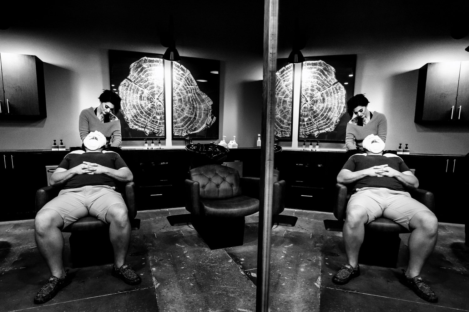 A candid black and white picture of a man getting a facial, his reflection visible in the mirror beside him on the morning of his summer wedding at Countryside Chalet in Kansas City. 