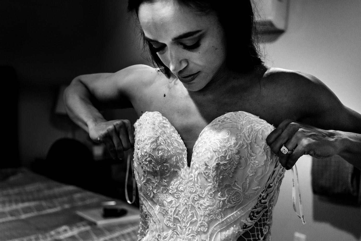 A candid black and white picture of a bride pulling up her wedding gown on the morning of her summer wedding day in Kansas City. 